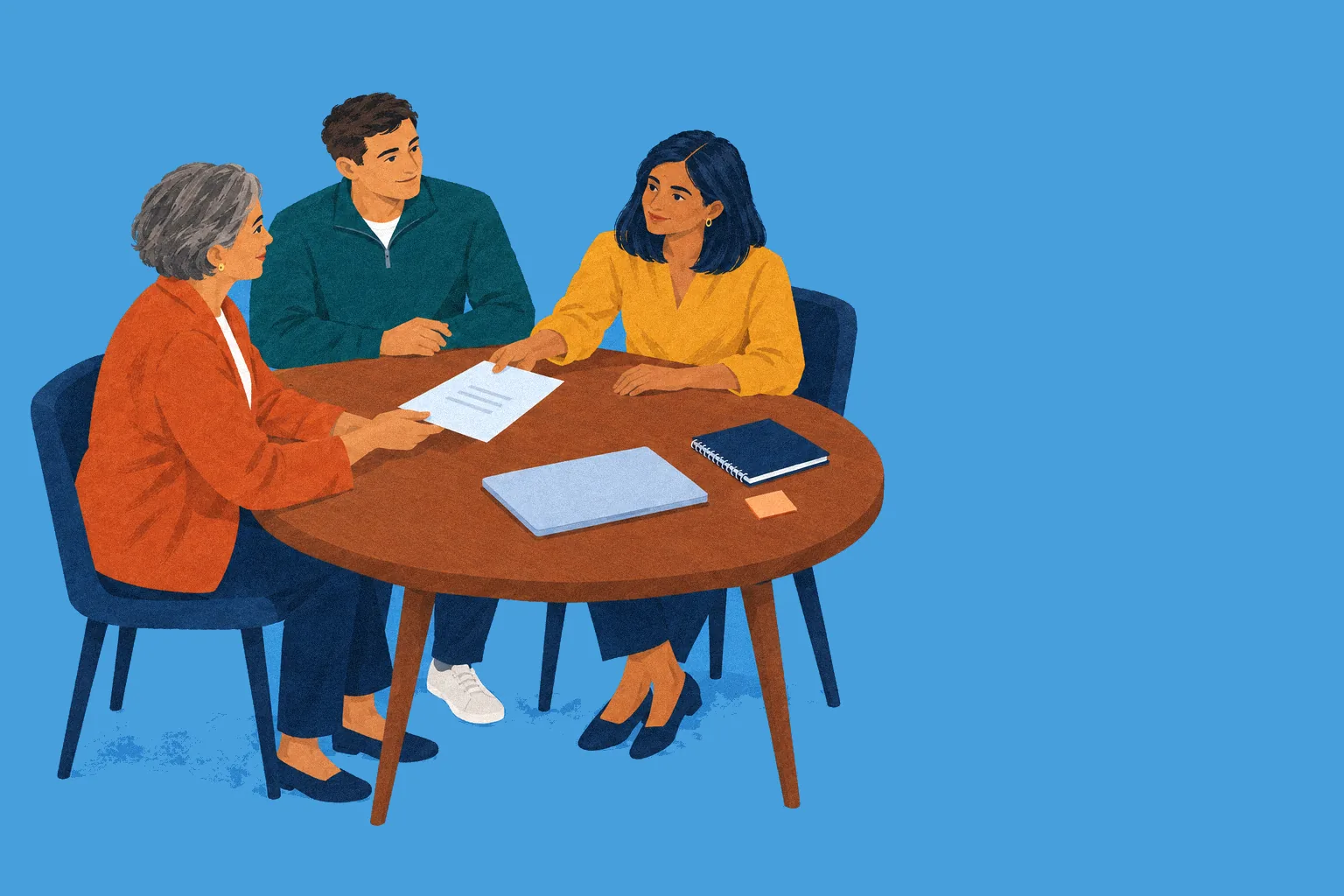 Three school staff talk over a page together at a round table.